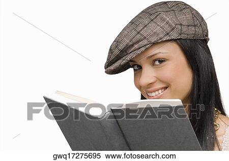 Portrait of a young woman smiling with a book in front of her View Large Photo Image Stock Photography - Portrait of a young woman smiling with a book in front of her. Fotosearch