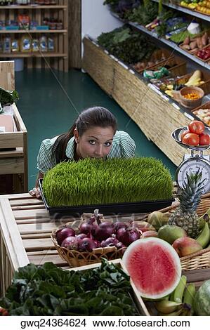 Picture - Portrait of a young woman standing in a grocery store. Fotosearch