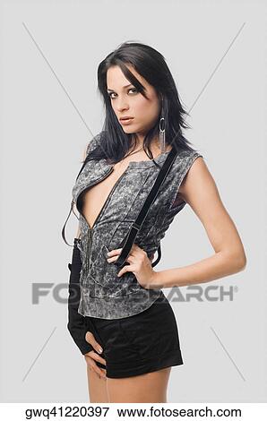 Portrait of a young woman standing with her hand on her hip View Large Photo Image Stock Photo - Portrait of a young woman standing with her hand on her hip. Fotosearch