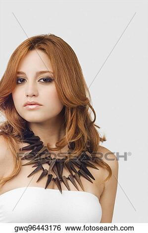Portrait of a young woman wearing a necklace View Large Photo Image Stock Photograph - Portrait of a young woman wearing a necklace. Fotosearch