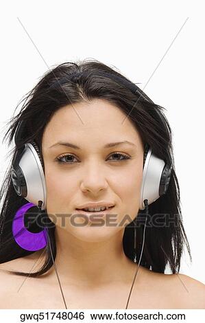 Stock Photograph - Portrait of a young woman wearing headphones and listening to music. Fotosearch