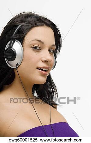 Portrait of a young woman wearing headphones and listening to music View Large Photo Image Stock Photography - Portrait of a young woman wearing headphones and listening to music. Fotosearch