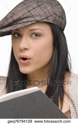 Portrait of a young woman whistling with a book in front of her View Large Photo Image Stock Photo - Portrait of a young woman whistling with a book in front of her. Fotosearch
