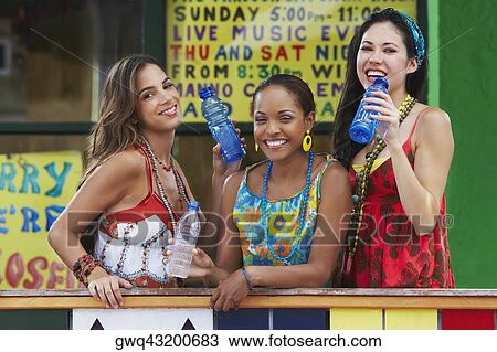 Portrait of three young women leaning on a railing and holding water bottles View Large Photo Image Stock Image - Portrait of three young women leaning on a railing and holding water bottles. Fotosearch