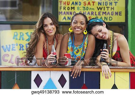 Portrait of three young women leaning on a railing and holding cold drinks View Large Photo Image Stock Image - Portrait of three young women leaning on a railing and holding cold drinks. Fotosearch