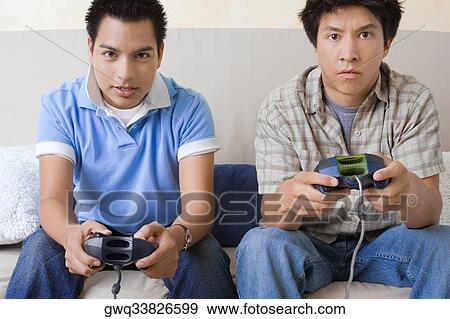Portrait of two young men playing video game View Large Photo Image Stock Photo - Portrait of two young men playing video game. Fotosearch