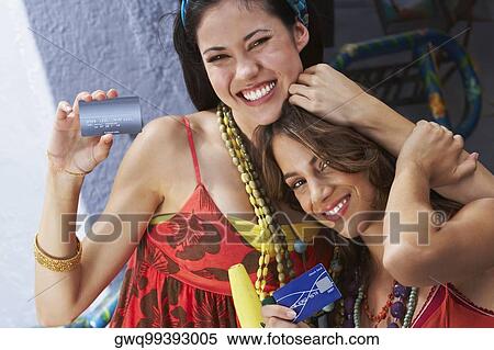 Portrait of two young women holding credit cards and smiling View Large Photo Image Stock Photography - Portrait of two young women holding credit cards and smiling. Fotosearch
