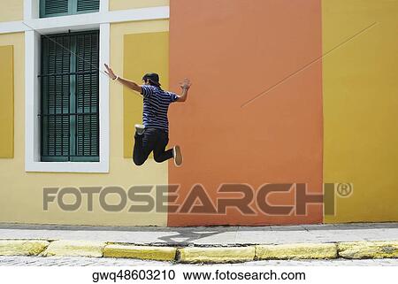 Rear view of a man jumping at the roadside View Large Photo Image Stock Image - Rear view of a man jumping at the roadside. Fotosearch