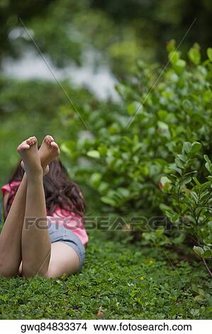 Picture - Rear view of a woman lying in a park. Fotosearch