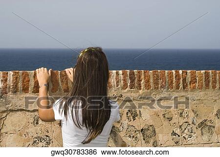 Rear view of a young woman looking over a castle wall, Morro Castle, Old San Juan, San Juan, Puerto Rico View Large Photo Image Stock Photograph - Rear view of a young woman looking over a castle wall, Morro Castle, Old San Juan, San Juan, Puerto Rico. Fotosearch