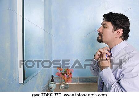 Side profile of a businessman adjusting his tie View Large Photo Image Stock Image - Side profile of a businessman adjusting his tie. Fotosearch