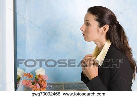 Side profile of a businesswoman adjusting collar of her shirts View Large Photo Image Stock Photo - Side profile of a businesswoman adjusting collar of her shirts. Fotosearch