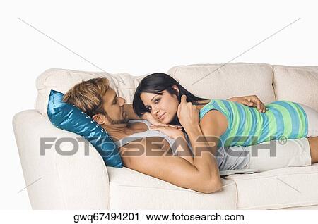 Side profile of a couple romancing on a couch View Large Photo Image Stock Image - Side profile of a couple romancing on a couch. Fotosearch
