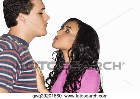 Stock Image - Side profile of a teenage girl and a young man face to face. Fotosearch