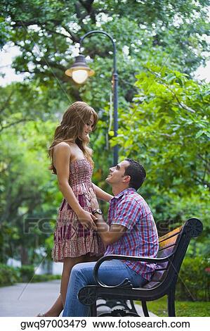 Side profile of a young couple romancing View Large Photo Image Stock Photo - Side profile of a young couple romancing. Fotosearch