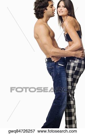 Stock Photo - Side profile of a young couple standing together. Fotosearch