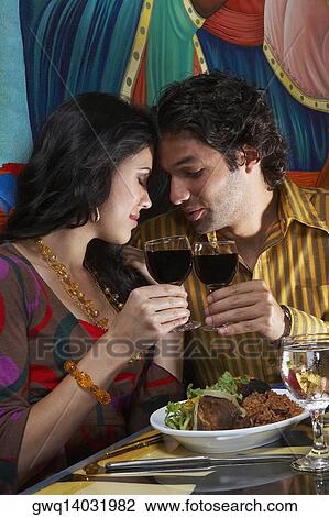 Side profile of a young couple toasting wine in a restaurant View Large Photo Image Stock Image - Side profile of a young couple toasting wine in a restaurant. Fotosearch