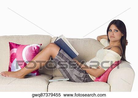 Side profile of a young woman reclining on a couch and holding a book View Large Photo Image Stock Photography - Side profile of a young woman reclining on a couch and holding a book. Fotosearch