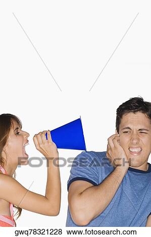 Side profile of a young woman shouting with a megaphone into a young man's ear View Large Photo Image Stock Photo - Side profile of a young woman shouting with a megaphone into a young man's ear. Fotosearch