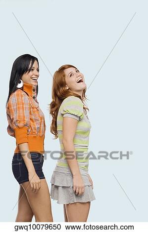 Side profile of two young women standing in a row and laughing View Large Photo Image Stock Image - Side profile of two young women standing in a row and laughing. Fotosearch