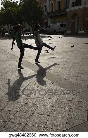 Side profile of two young women walking View Large Photo Image Stock Image - Side profile of two young women walking. Fotosearch