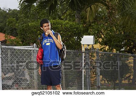 Teenage boy listening an ipod and eating empanada View Large Photo Image Stock Image - Teenage boy listening an ipod and eating empanada. Fotosearch