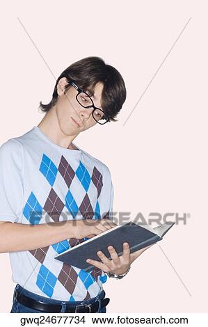 Teenage boy standing and reading a book View Large Photo Image Picture - Teenage boy standing and reading a book. Fotosearch