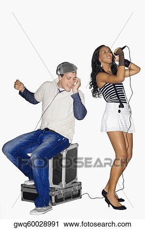 Teenage girl singing and a young man listening to music View Large Photo Image Stock Image - Teenage girl singing and a young man listening to music. Fotosearch