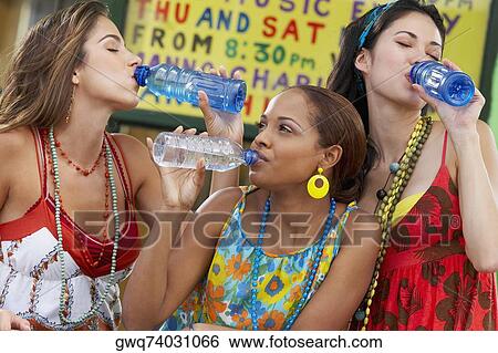 Stock Photograph - Three young women drinking water from bottles. Fotosearch