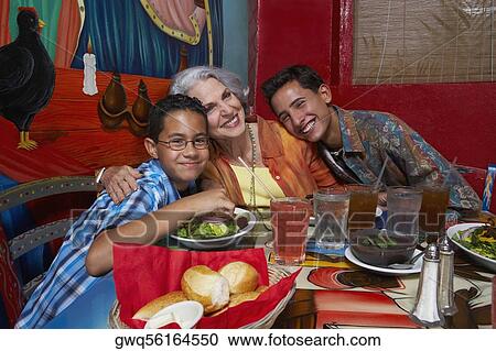 Two boys sitting with their grandmother in a restaurant View Large Photo Image Stock Image - Two boys sitting with their grandmother in a restaurant. Fotosearch