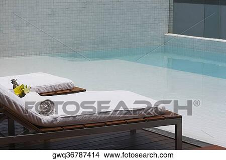 Two lounge chairs at the poolside View Large Photo Image Picture - Two lounge chairs at the poolside. Fotosearch