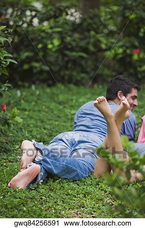 Young couple lying in a park View Large Photo Image Stock Image - Young couple lying in a park. Fotosearch