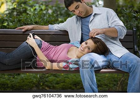 Young couple romancing in a park View Large Photo Image Stock Photograph - Young couple romancing in a park. Fotosearch
