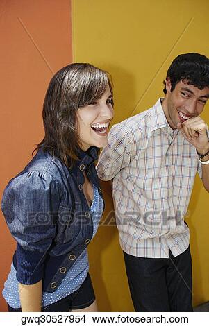 Young couple standing together and smiling View Large Photo Image Picture - Young couple standing together and smiling. Fotosearch
