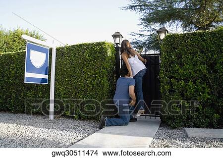 Young man boosting young woman over fence View Large Photo Image Picture - Young man boosting young woman over fence. Fotosearch