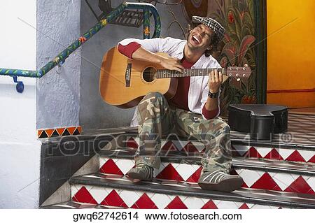 Young man playing a guitar and singing View Large Photo Image Picture - Young man playing a guitar and singing. Fotosearch