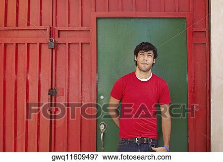 Young man standing in front of a closed door View Large Photo Image Stock Photo - Young man standing in front of a closed door. Fotosearch