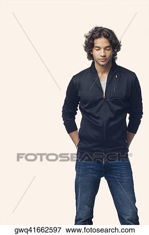 Young man standing with his hands in his pockets View Large Photo Image Stock Photo - Young man standing with his hands in his pockets. Fotosearch