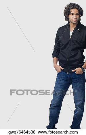 Stock Photo - Young man standing with his hands in his pockets. Fotosearch