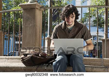 Stock Photo - Young man using a laptop. Fotosearch