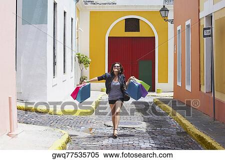 Stock Photography - Young woman carrying shopping bags and smiling, Old San Juan, San Juan, Puerto Rico. Fotosearch