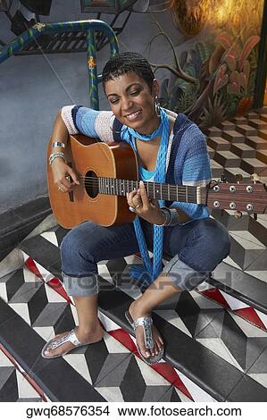 Young woman playing a guitar View Large Photo Image Picture - Young woman playing a guitar. Fotosearch