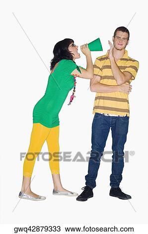 Young woman shouting with a megaphone into a young man's ear View Large Photo Image Stock Image - Young woman shouting with a megaphone into a young man's ear. Fotosearch