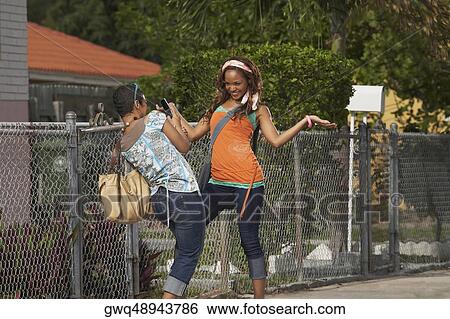 Young woman taking a photograph of her friend View Large Photo Image Stock Photograph - Young woman taking a photograph of her friend. Fotosearch