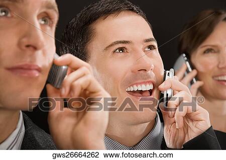 Business executives talking on mobile phones and smiling View Large Photo Image Stock Image - Business executives talking on mobile phones and smiling. Fotosearch