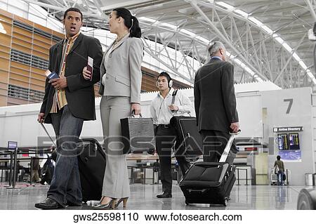 Business executives walking at an airport View Large Photo Image Stock Image - Business executives walking at an airport. Fotosearch