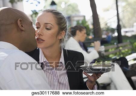 Stock Photo - Businessman kissing a businesswoman. Fotosearch