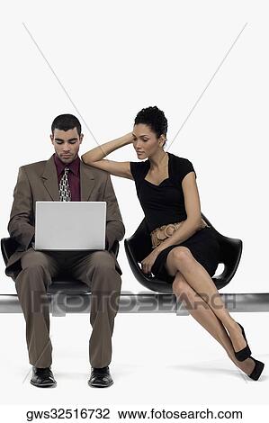 Businessman using a laptop and a businesswoman leaning on his shoulder View Large Photo Image Stock Image - Businessman using a laptop and a businesswoman leaning on his shoulder. Fotosearch