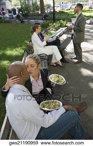 Businesswoman kissing a businessman with three business executives in the background View Large Photo Image Stock Photo - Businesswoman kissing a businessman with three business executives in the background. Fotosearch