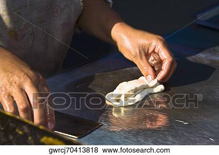 Stock Photo - Chef's hand preparing a seedcake, HohHot, Inner Mongolia, China. Fotosearch
